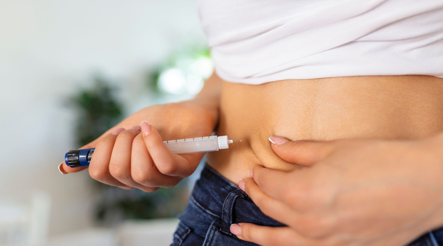 Женщина показывает, как использовать инъекционную ручку для похудения